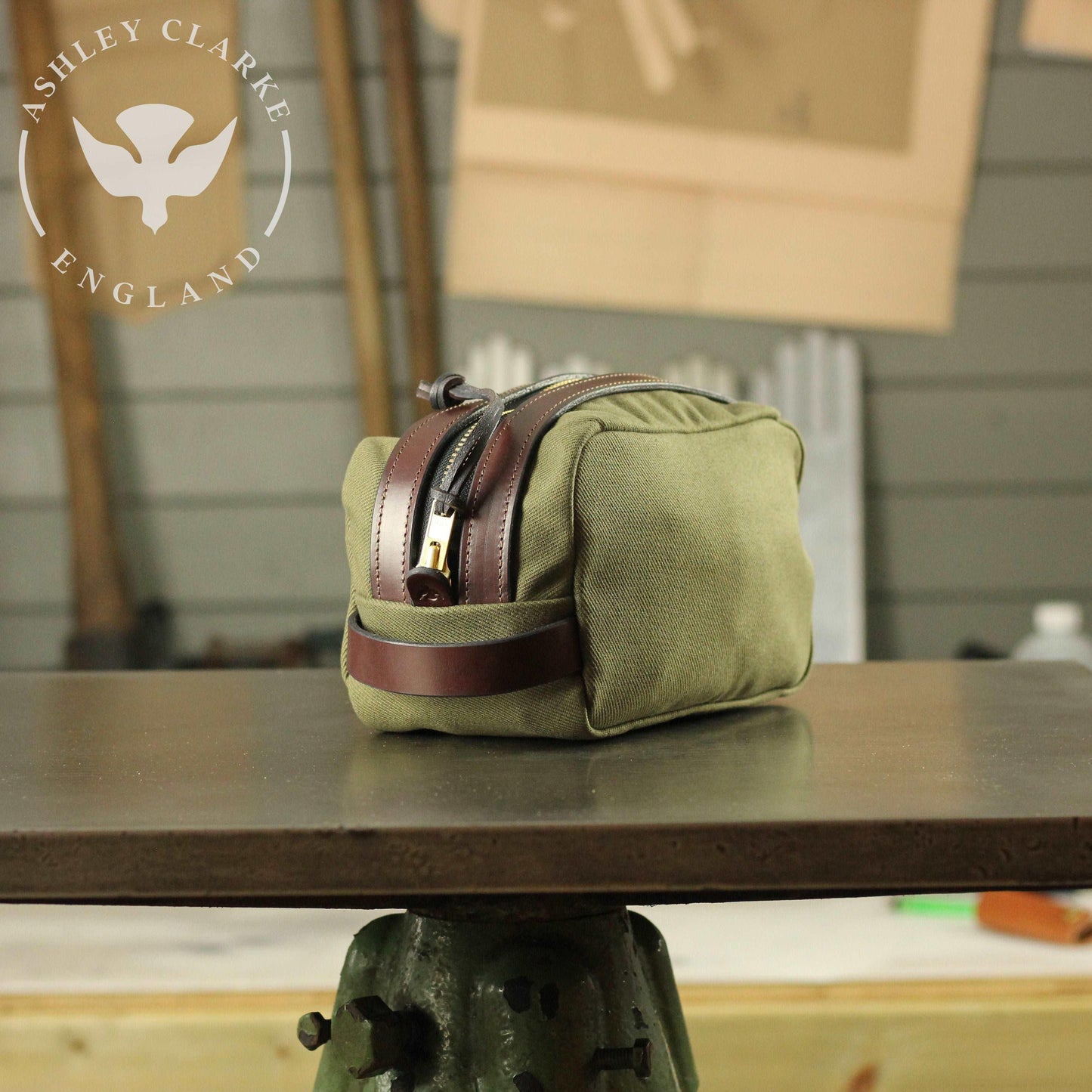 side view of a waxed canvas wash bag by ashley clarke england on top of a table workshop 