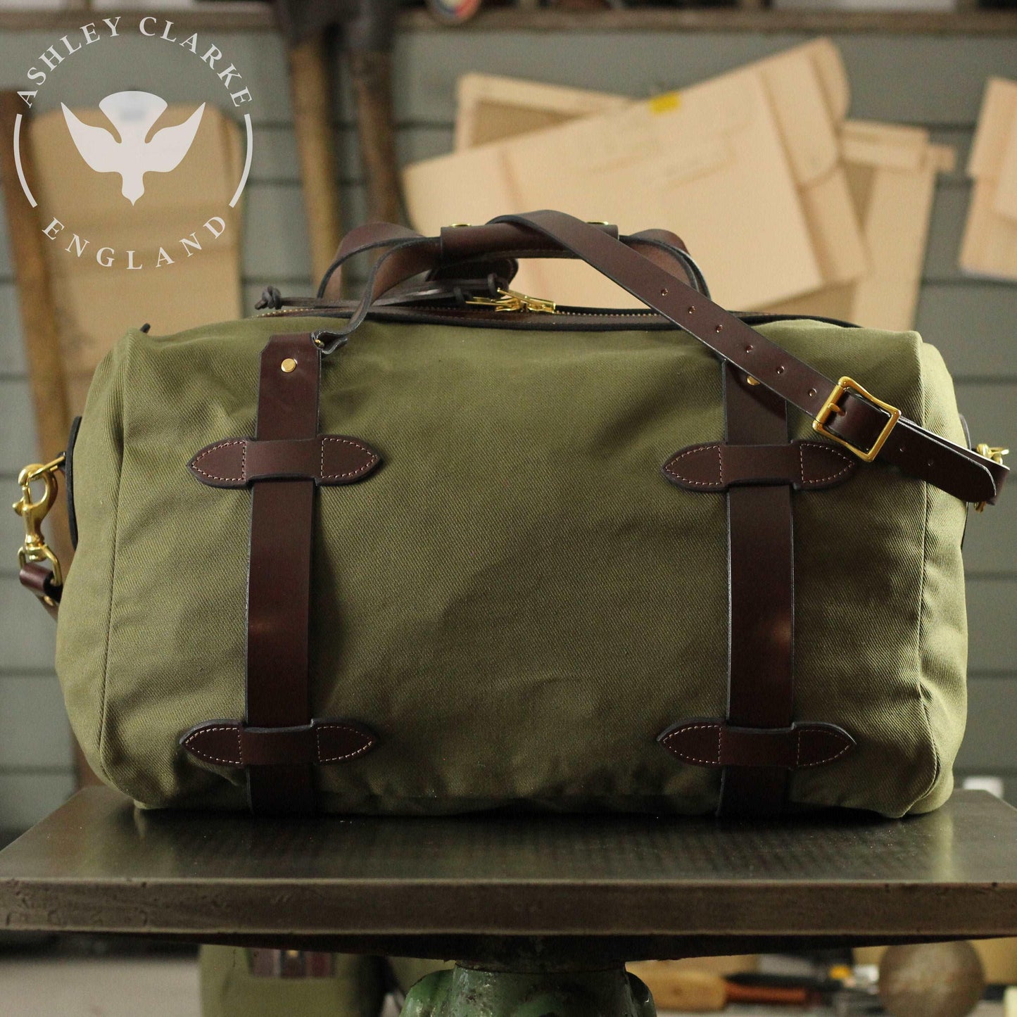 a green waxed canvas holdall bag by ashley clarke england on top of a table 1