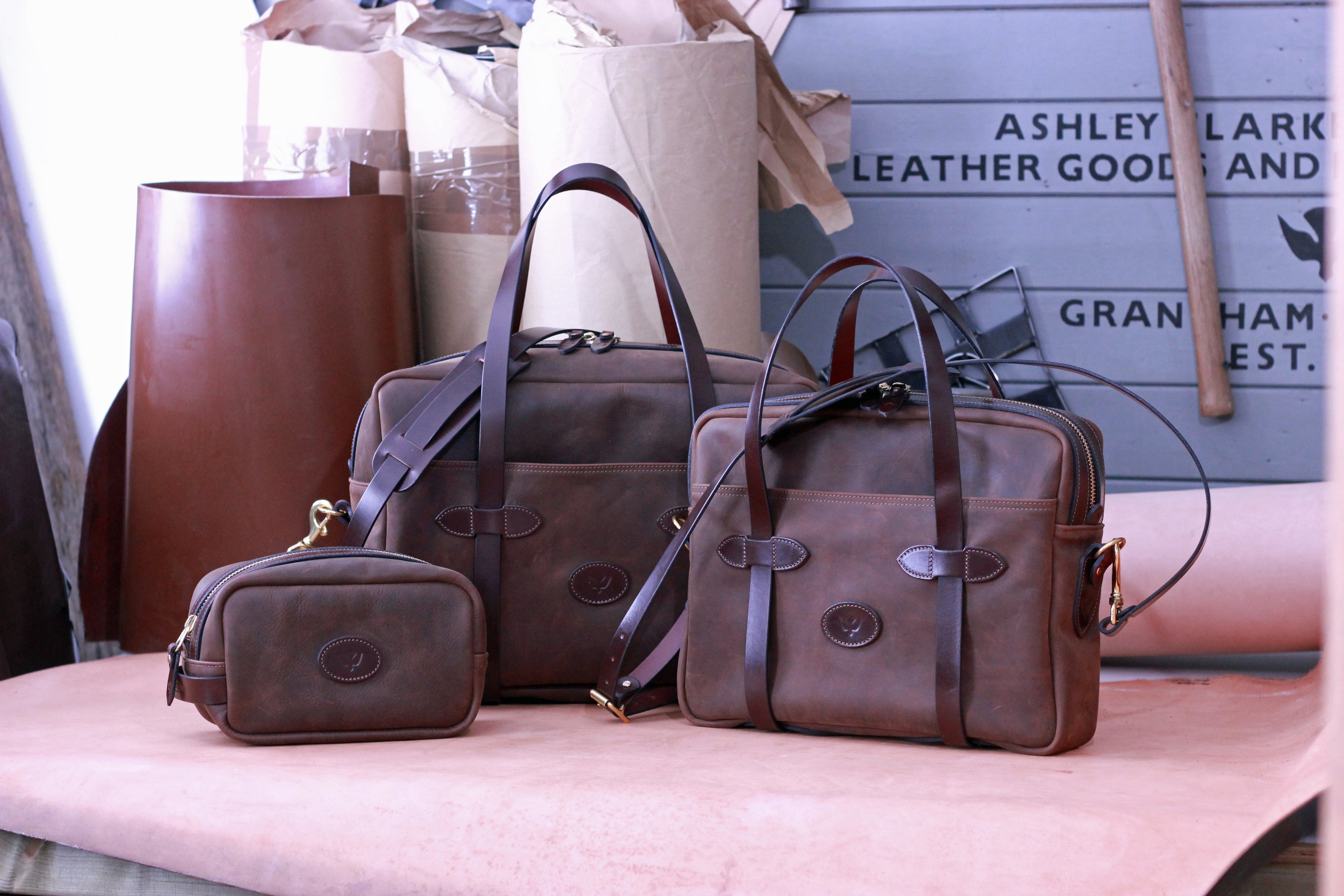 A range of 3 leather bags on a workbench