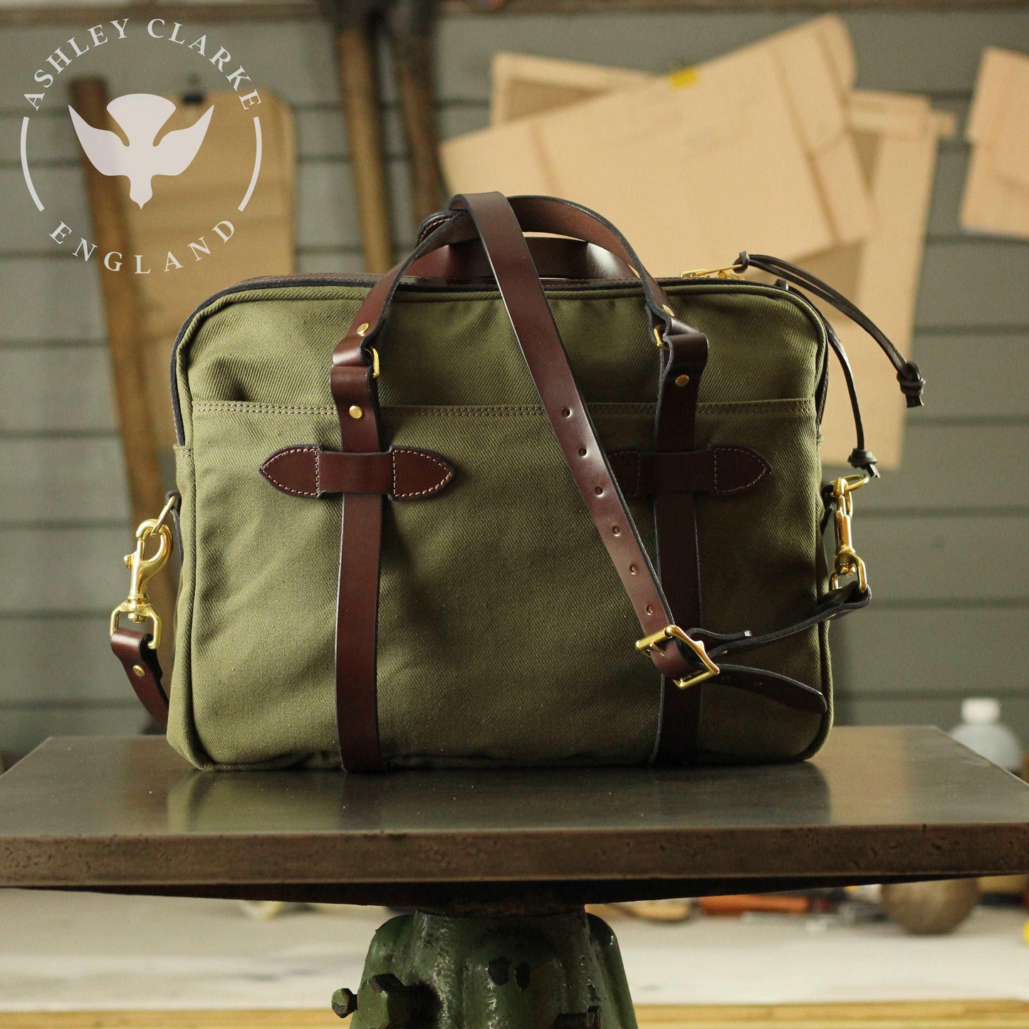 back view of a green waxed canvas briefcase laptop bag by ashley clarke on a table