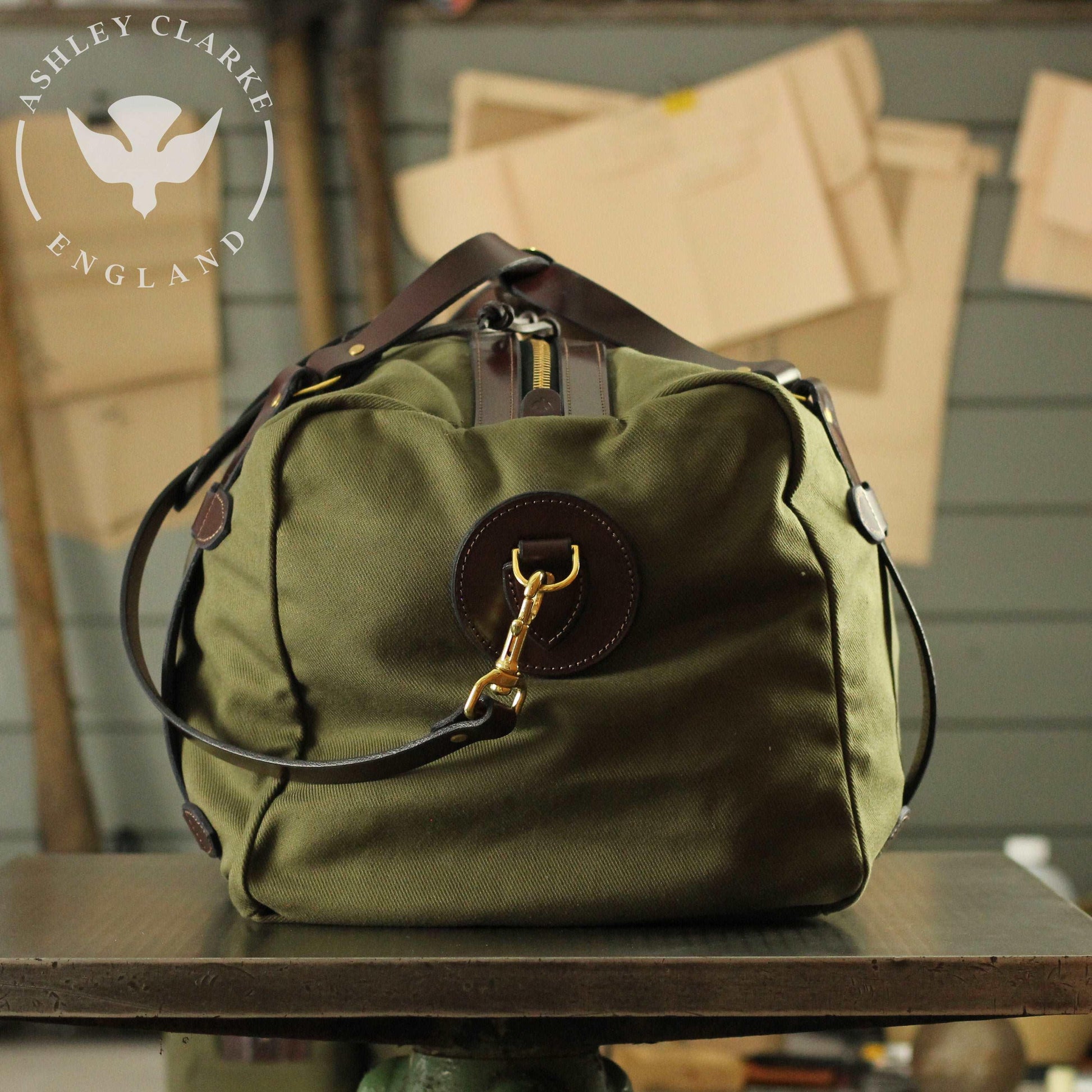 a green waxed canvas holdall bag by ashley clarke england on top of a table 4
